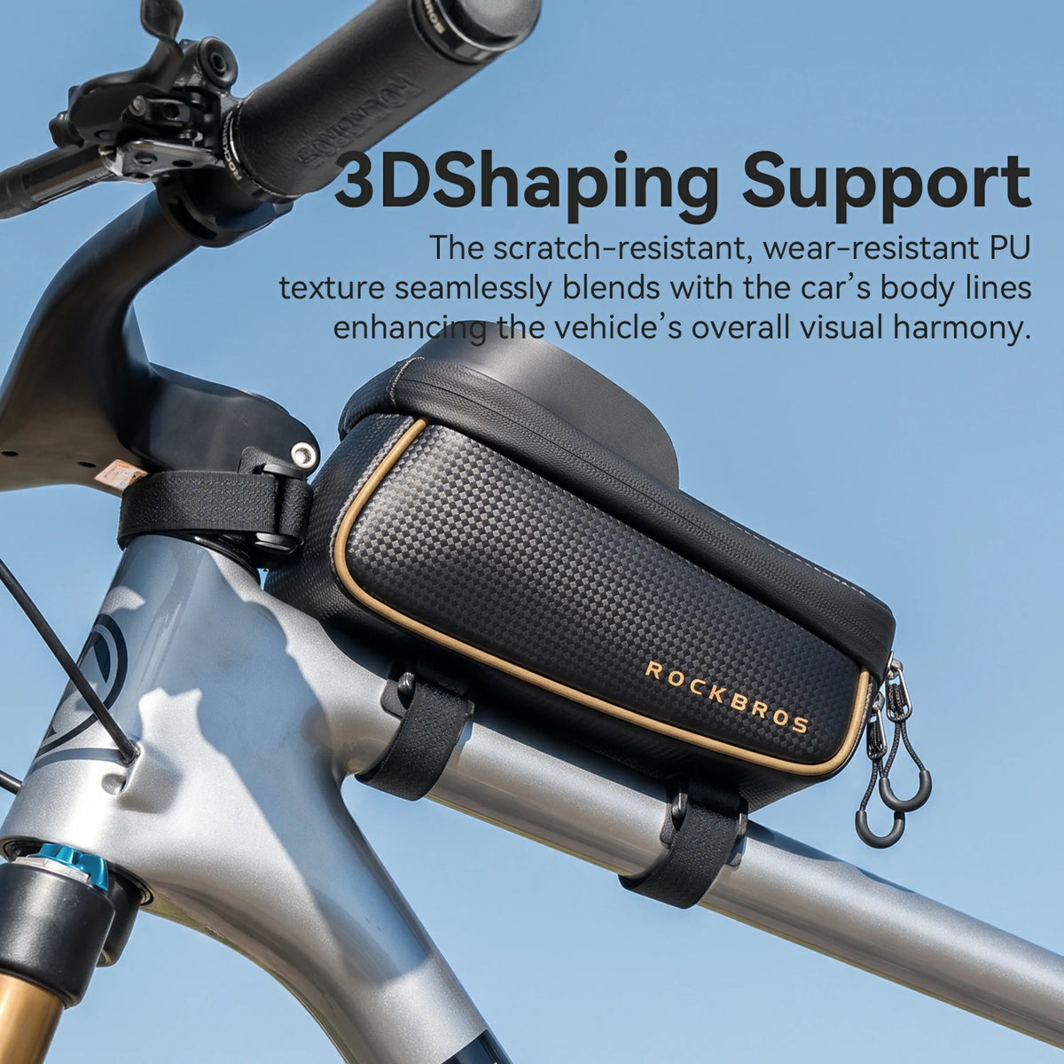 A black ROCKBROS bicycle handlebar bag mounted on a silver bicycle frame against a blue sky background, with promotional text overlay.