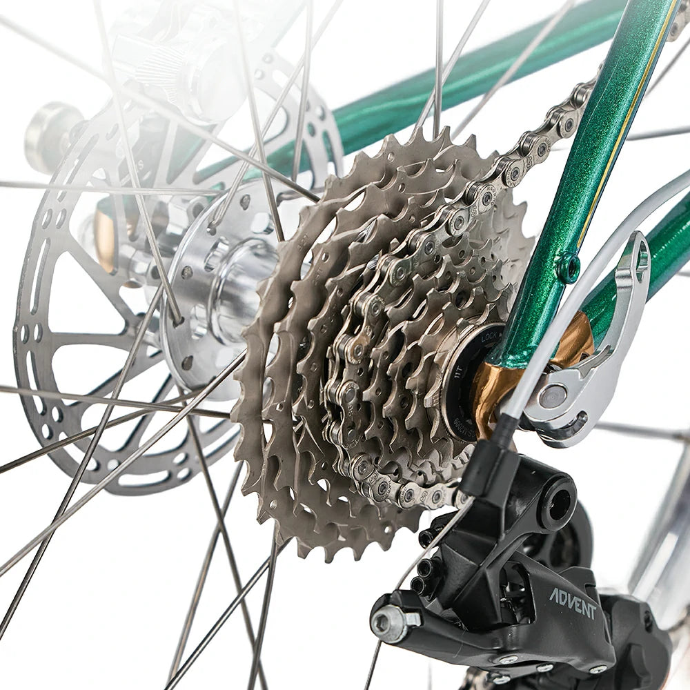 Close-up of a bicycle's gear system with a green frame. #Color_Green
