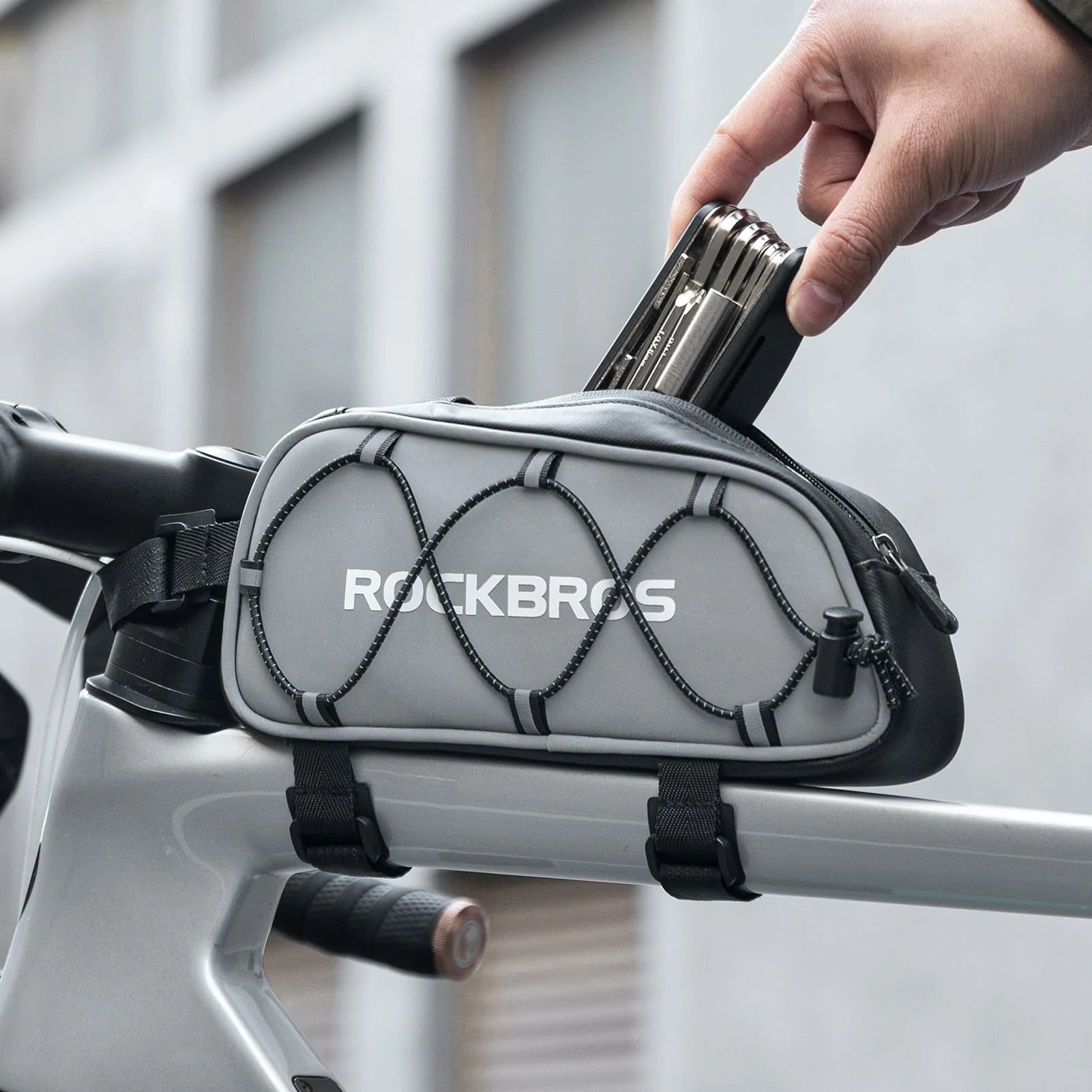 Gray bike frame bag with 'RockBros' branding attached to a bicycle handlebar. #color_silver