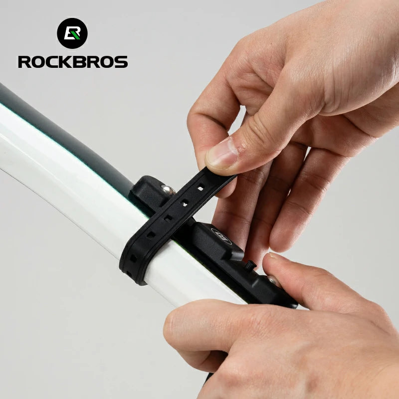 Person adjusting a black bike mount on a white background with RockBros branding.