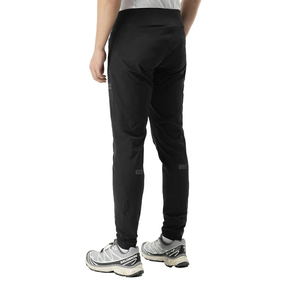 Black athletic jogger pants shown from the back on a model, paired with gray running shoes against a plain white background.