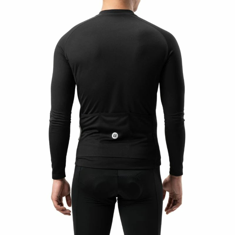 Rear view of a person wearing a black long-sleeve cycling base layer with a built-in rear pocket and a small circular logo, paired with black cycling shorts against a white background. #Color_Black