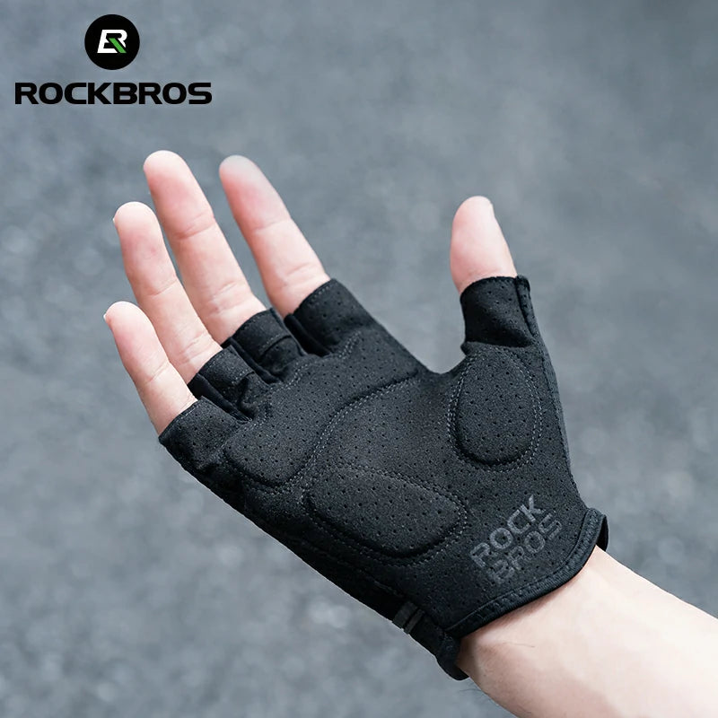 Black half-finger glove on a hand with a gray background, featuring the RockBros brand. #color_black