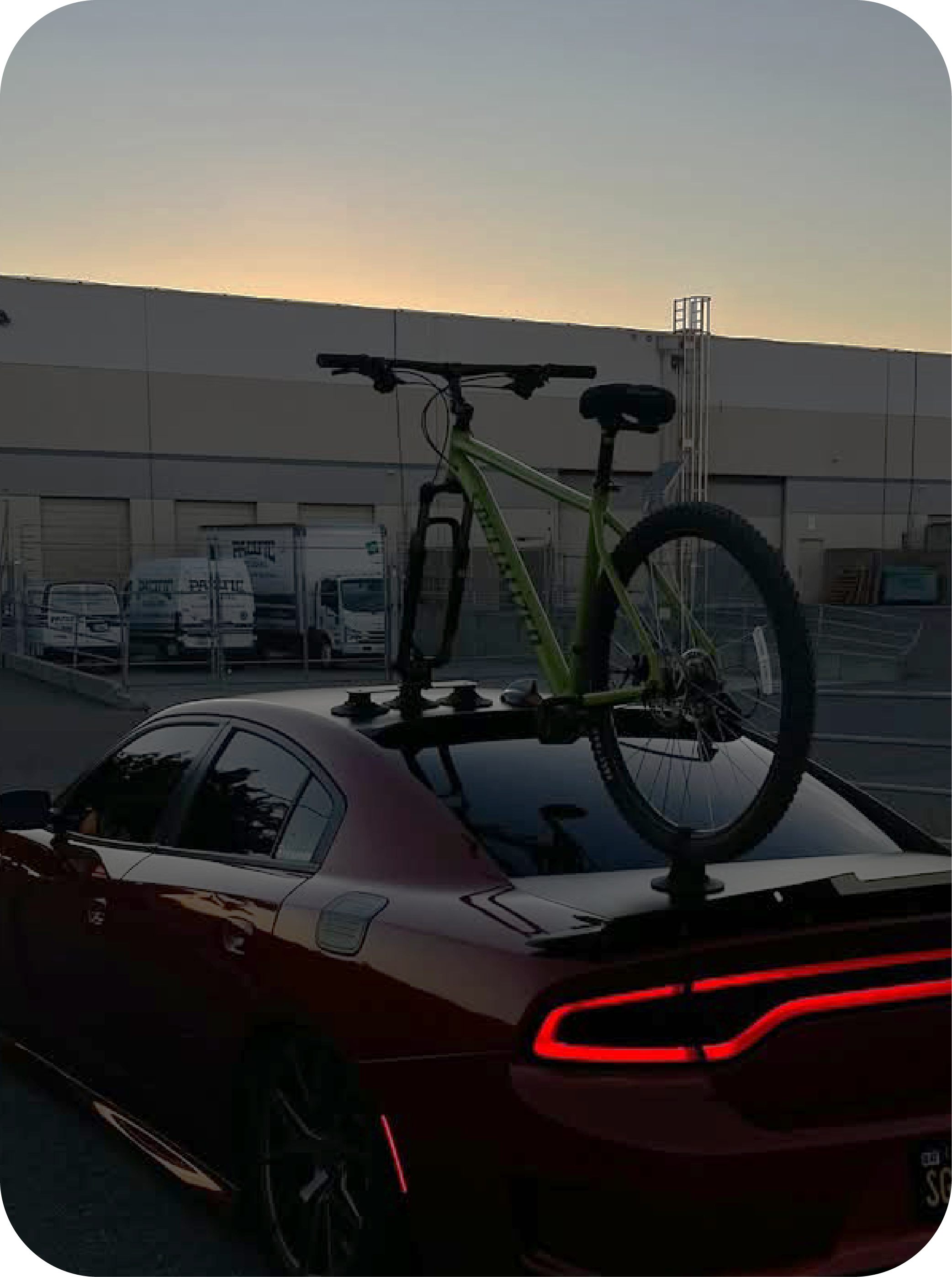 Bicycle on a ROCKBROS car roof rack with a building and sunset in the background