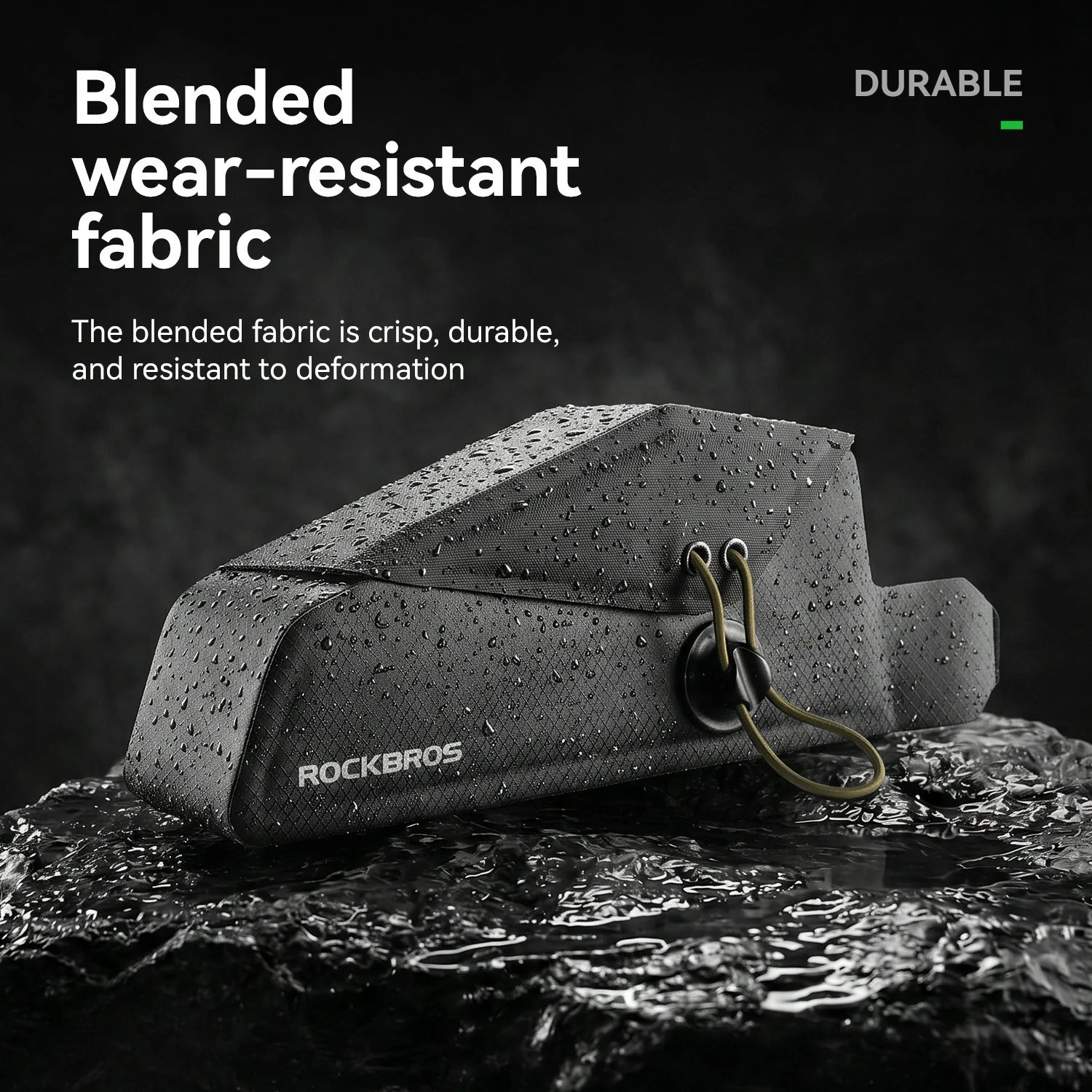 A black Rockbros bag with water droplets on its surface, resting on wet rocks with promotional text highlighting its durable, blended wear-resistant fabric.