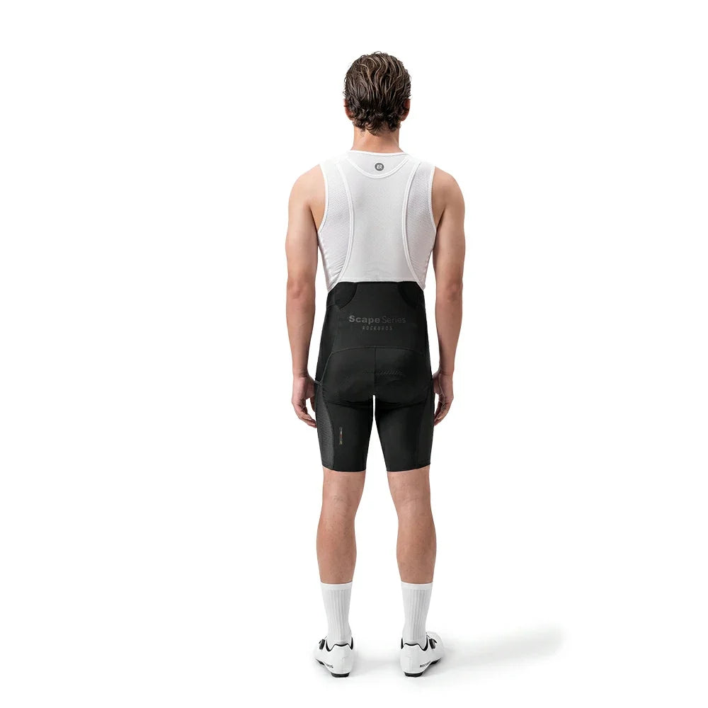 A man shown from the back wearing a white cycling bib jersey and black cycling shorts with a small white logo on the back waistband, standing against a plain white studio background.