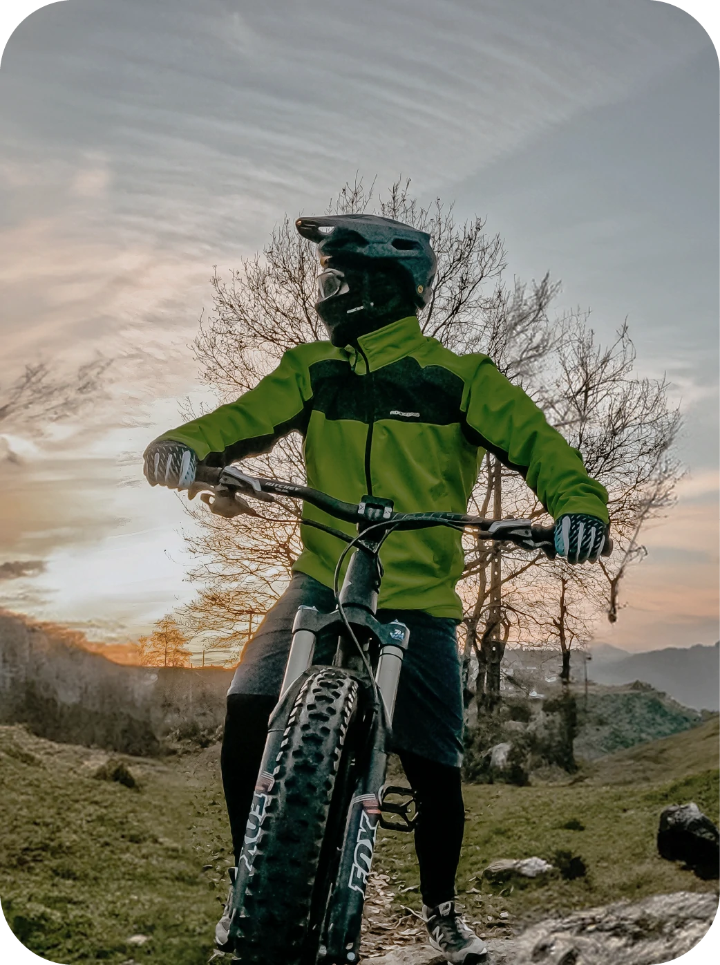 Person wears ROCKBROS Cycling Jack on a mountain bike with a scenic background