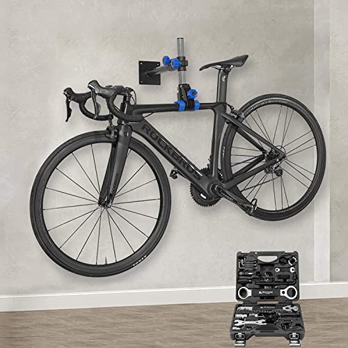 Bicycle mounted on a wall with a tool set below in a room.