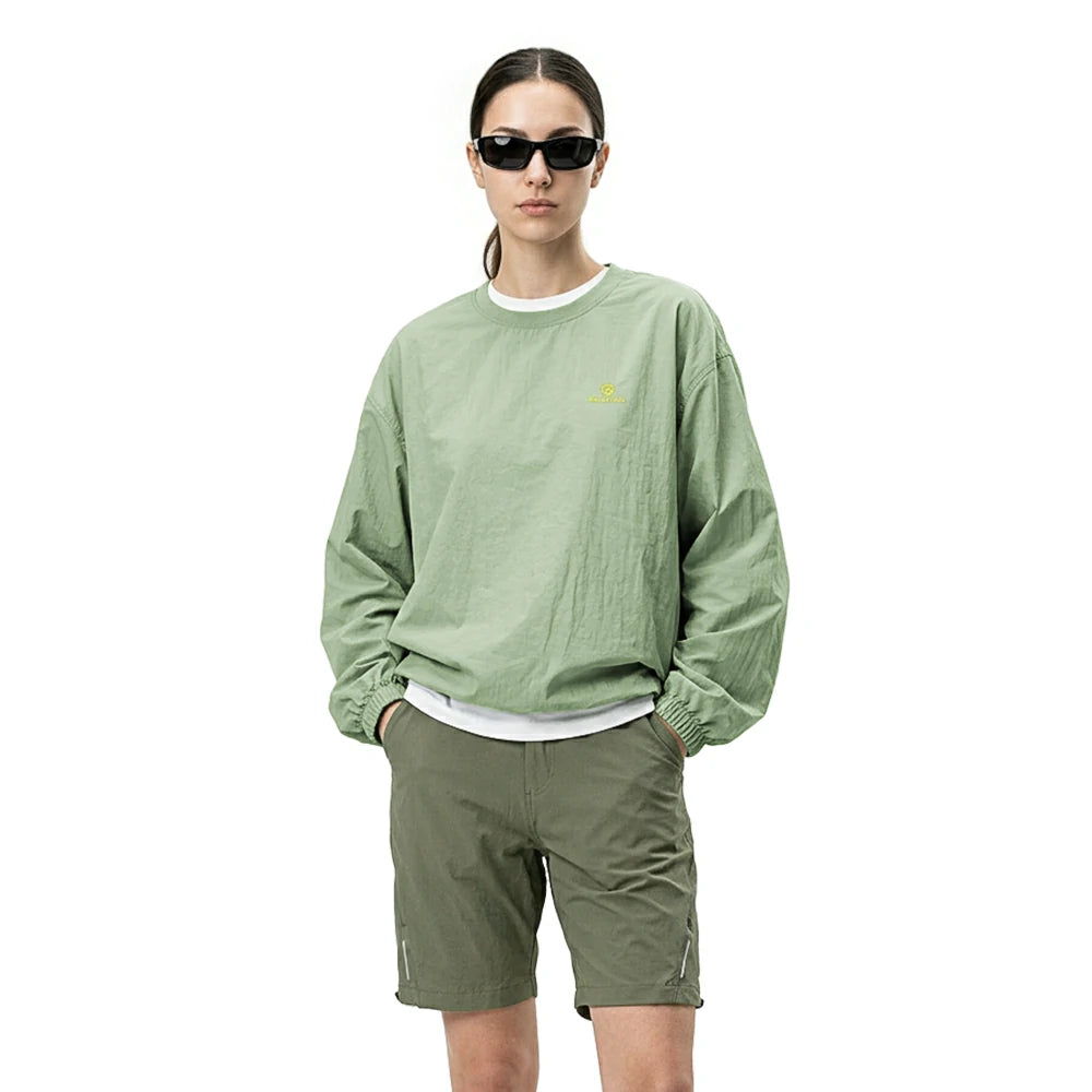 Person wearing a green sweatshirt and shorts on a white background