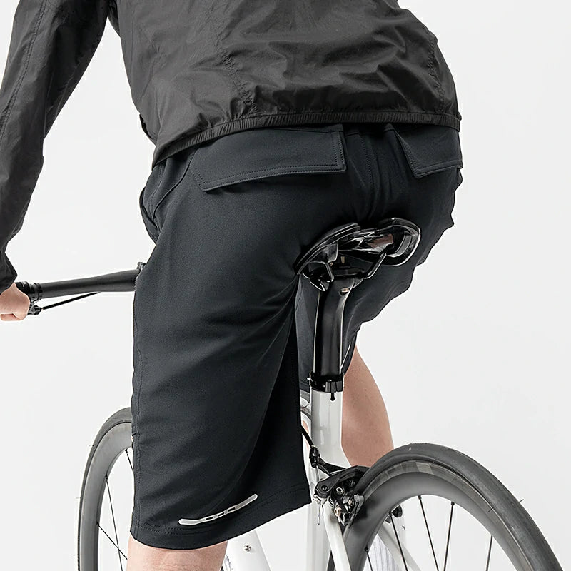 Person wearing black cycling shorts on a bicycle against a white background