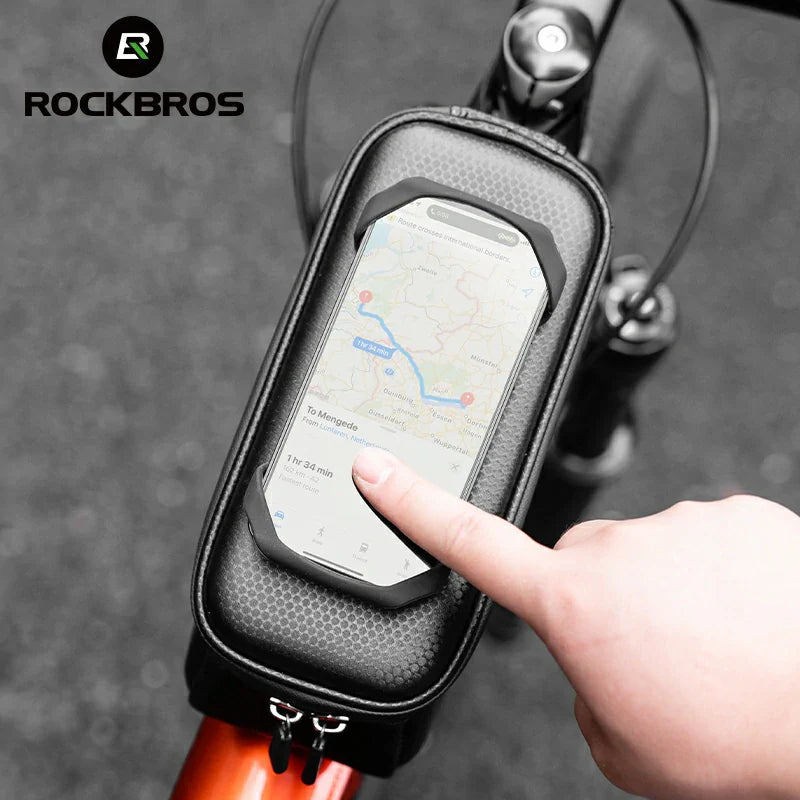 Bicycle phone holder with a smartphone displaying a map, held by a hand, on a blurred background with 'Rockbros' branding.