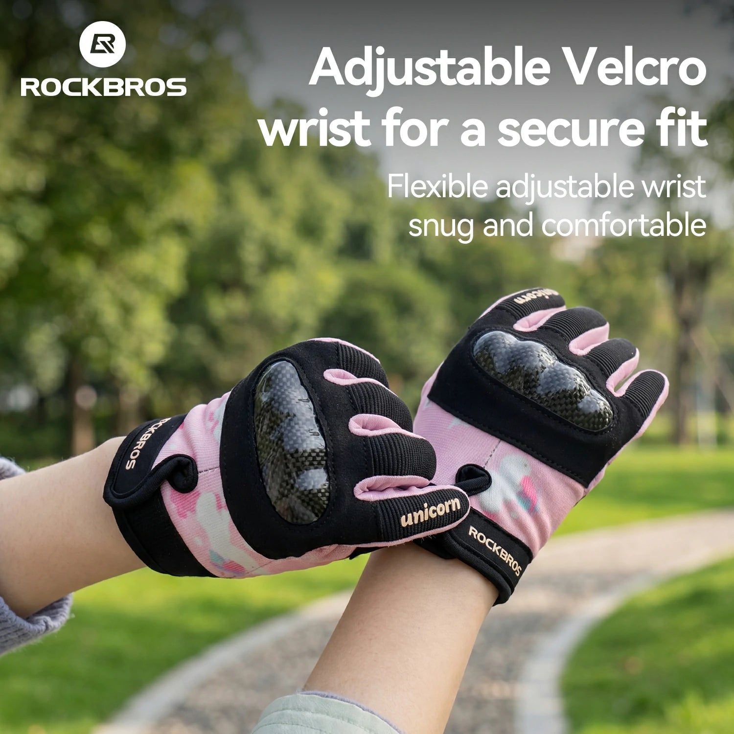 Pink and black gloves with adjustable velcro wrist on a blurred outdoor background