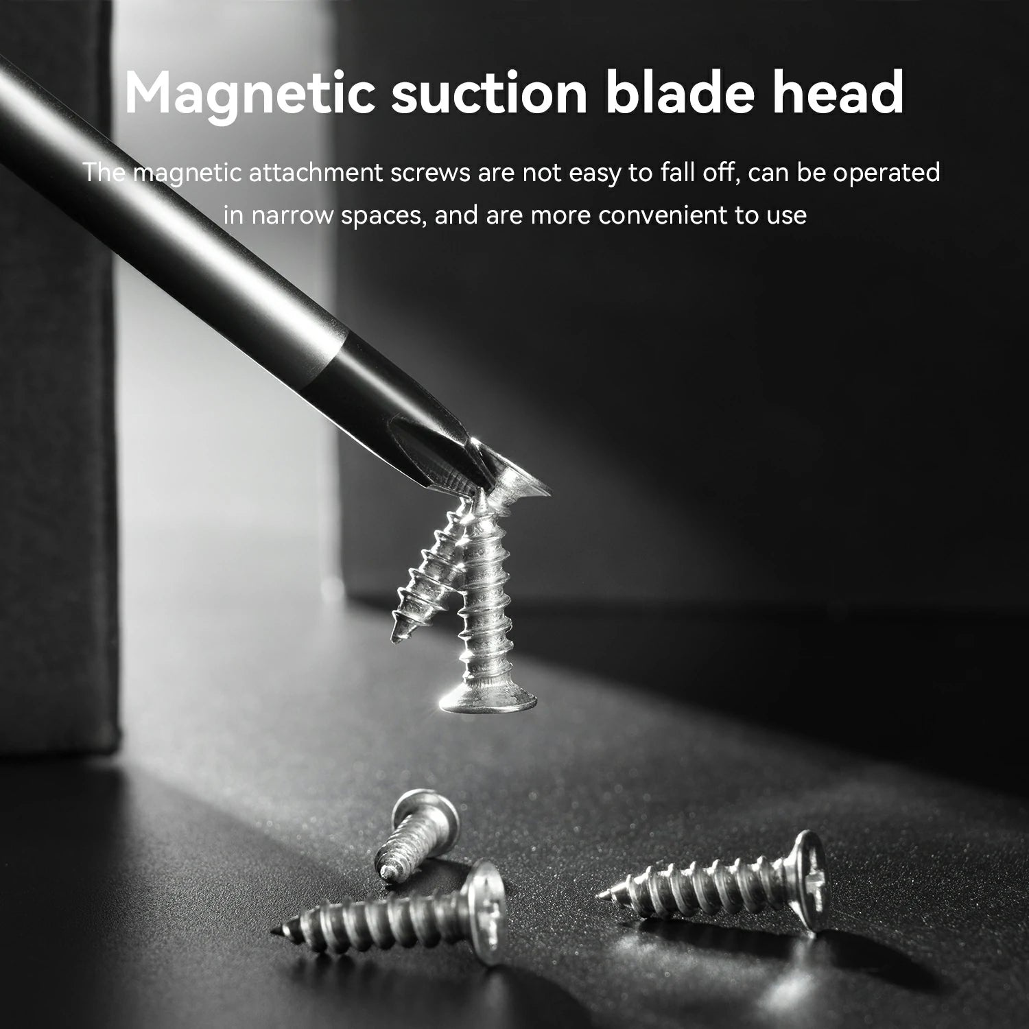 A close-up product demonstration showing a magnetic suction blade head attached to a screwdriver bit, holding a metal screw against a dark surface. White text at the top reads 'Magnetic suction blade head' with additional descriptive copy below, and several loose screws are scattered on the surface.