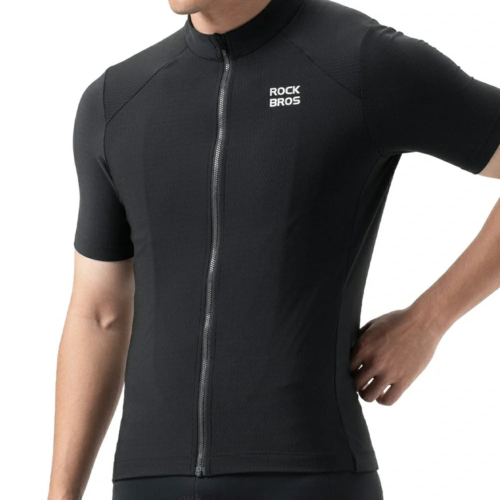 A close-up of a person wearing a black short-sleeve cycling jersey with a full front zipper and a white 'ROCK BROS' logo on the left chest, against a plain white background. #Color_Black