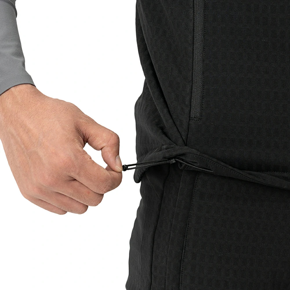 Close-up of a person's hand fastening a black waist tie on a textured black jacket against a white background.