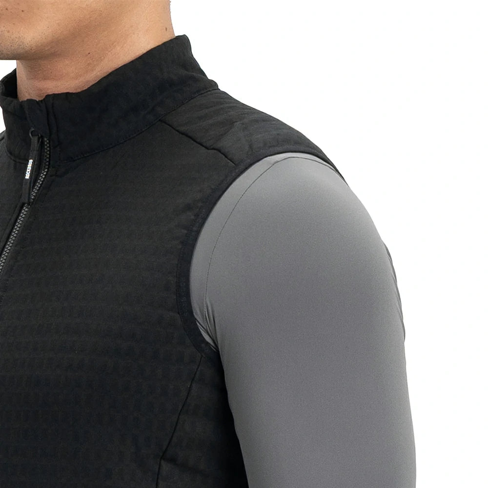 Close-up of a person wearing a black sleeveless zip-front vest over a fitted gray long-sleeve base layer, shown against a plain white background.