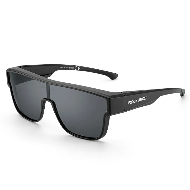 Black shield-style sunglasses with dark tinted lenses and visible ROCKBROS branding on the temple, shown on a clean white background. #Color_Black
