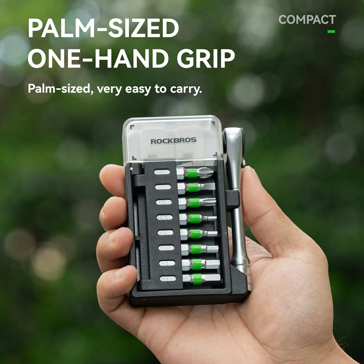Compact tool set with screwdrivers held in a palm-sized case against a blurred green background