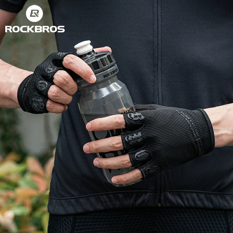Person holding a water bottle with gloves on, wearing a black jacket with 'RockBros' branding.  #color_black